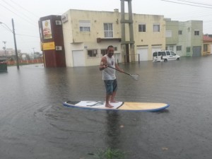 Homem pratica stand-up paddle em rua alagada de Rio Grande (Foto: Julieta Amaral/RBS TV)